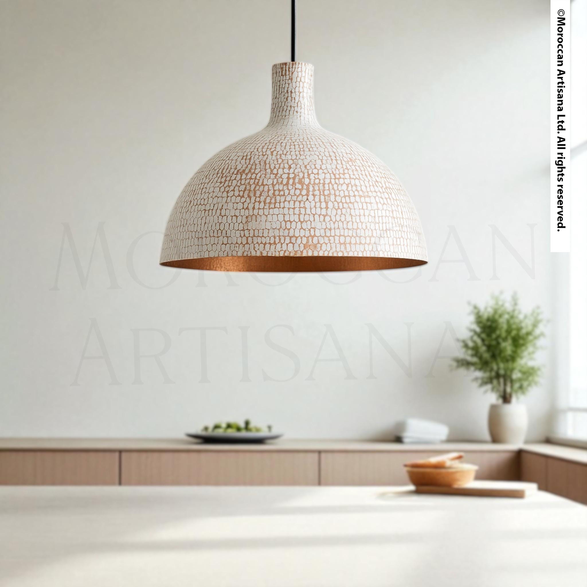a modern, minimalist kitchen interior with a large, textured pendant light hanging from the ceiling, a wooden table with a bowl and a plant, and a wall with a large text logo.