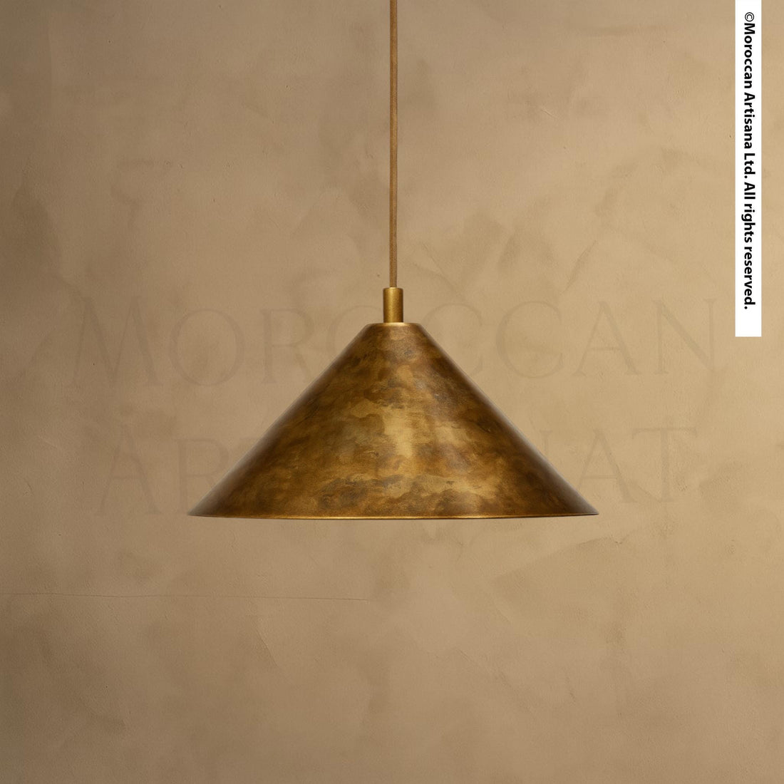 A single, gold-colored pendant light hangs from the ceiling against a beige wall.