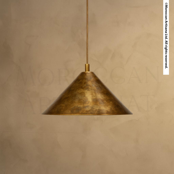 A single, gold-colored pendant light hangs from the ceiling against a beige wall.