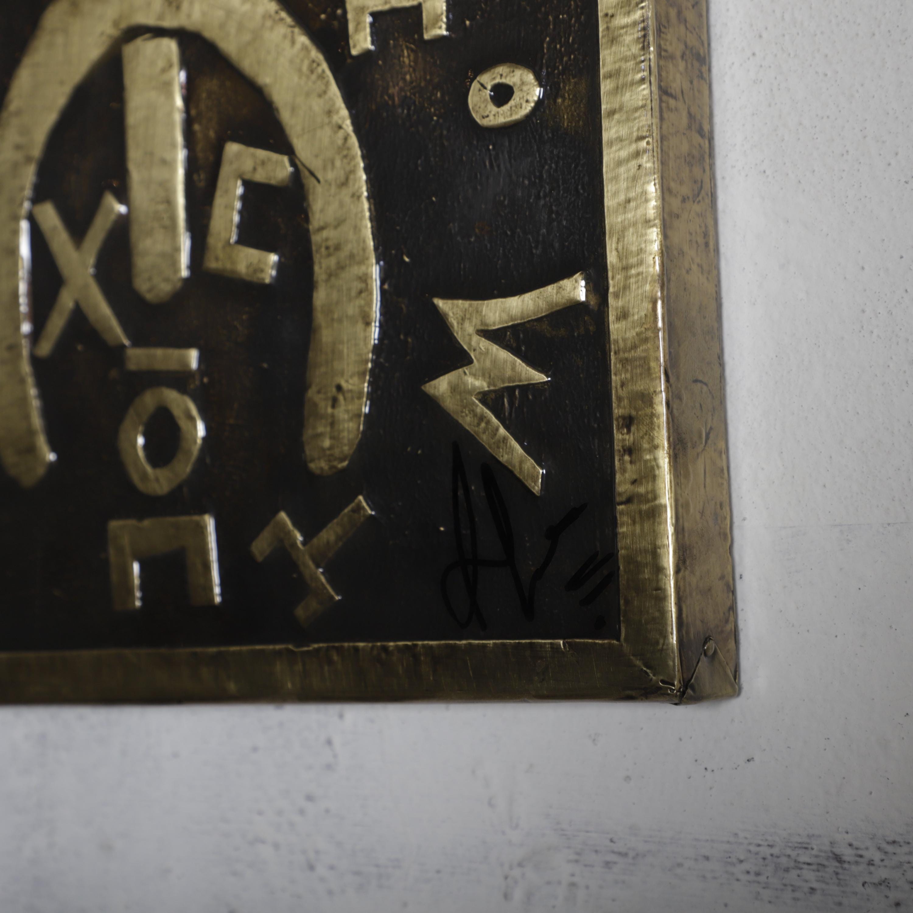 a close-up view of a dark, textured surface with a few distinct shapes and symbols.