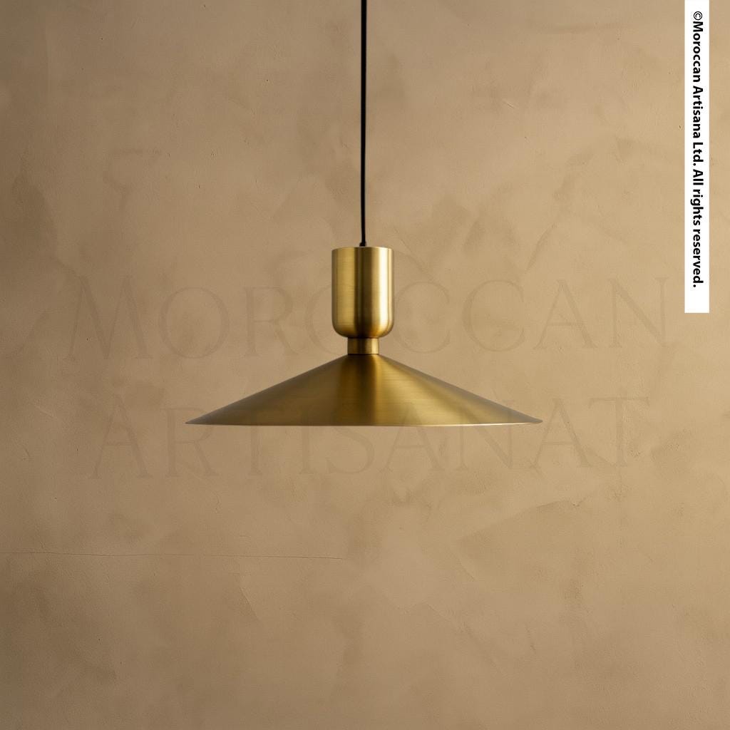 A gold-colored pendant light hangs from the ceiling against a beige wall.