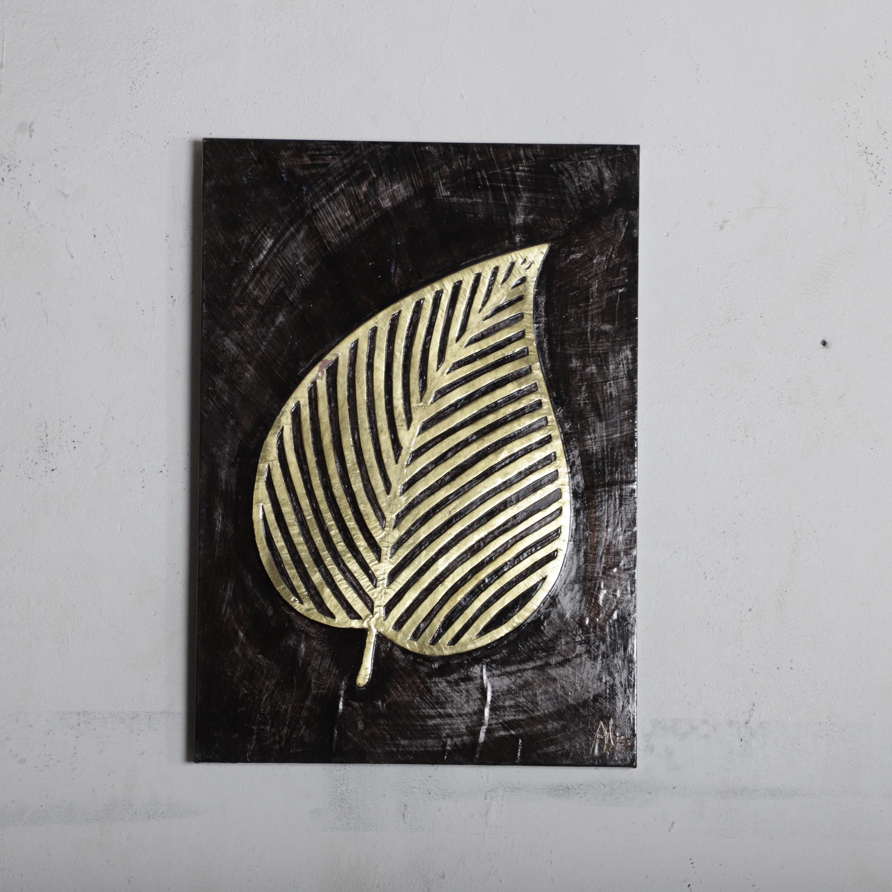 a black and white leaf with a gold-colored design on a dark background.