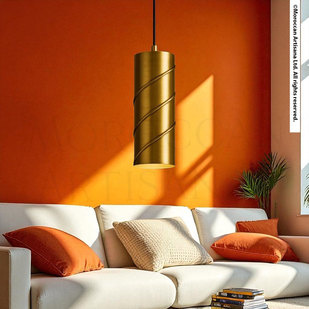 a modern living room with a white sofa and a gold pendant lamp hanging above it. The room has a warm, inviting atmosphere with orange walls and a large window allowing natural light to fill the space.