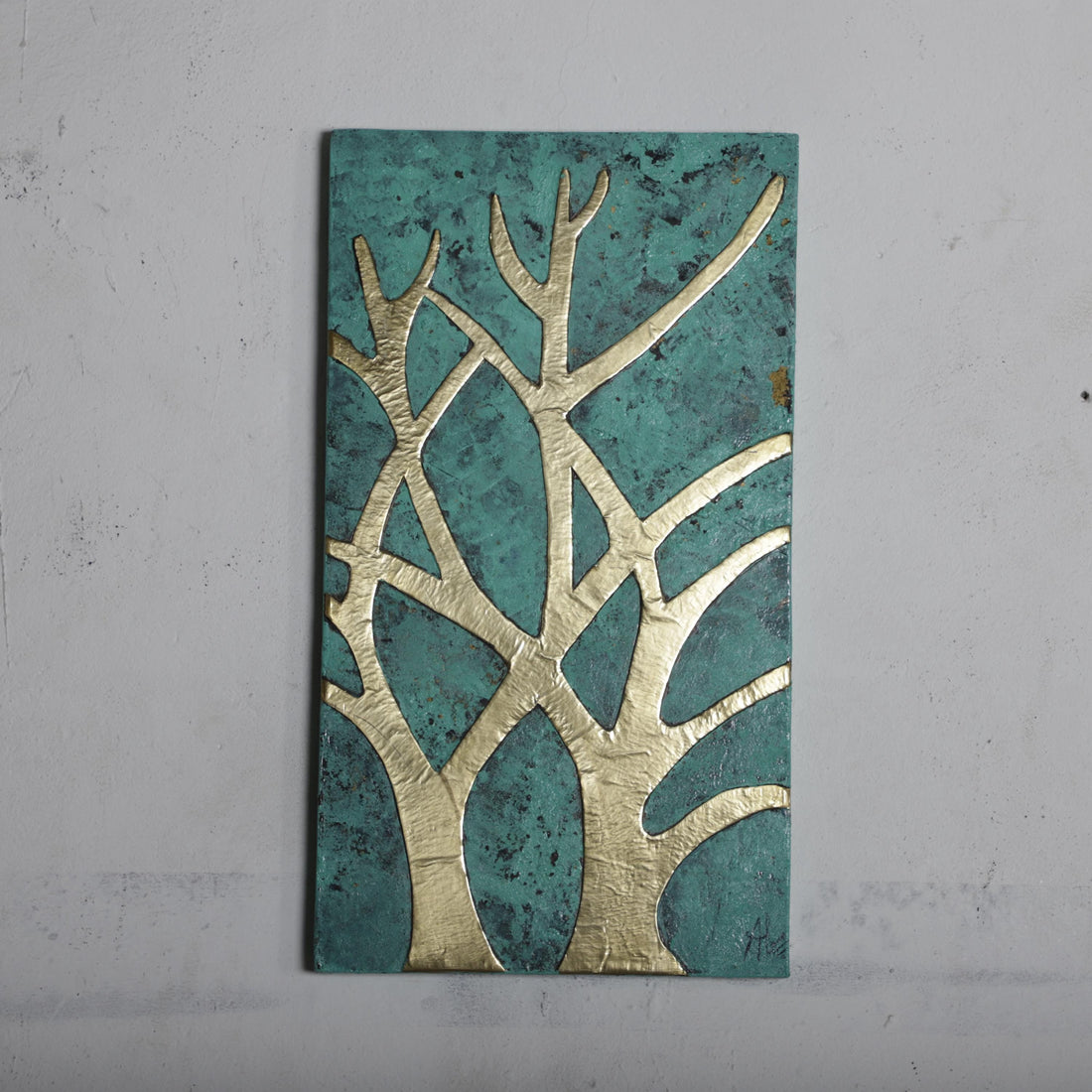 a rectangular piece of art with a tree-like design on it, set against a green background.