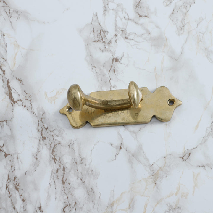 a brass dog bone on a marble surface