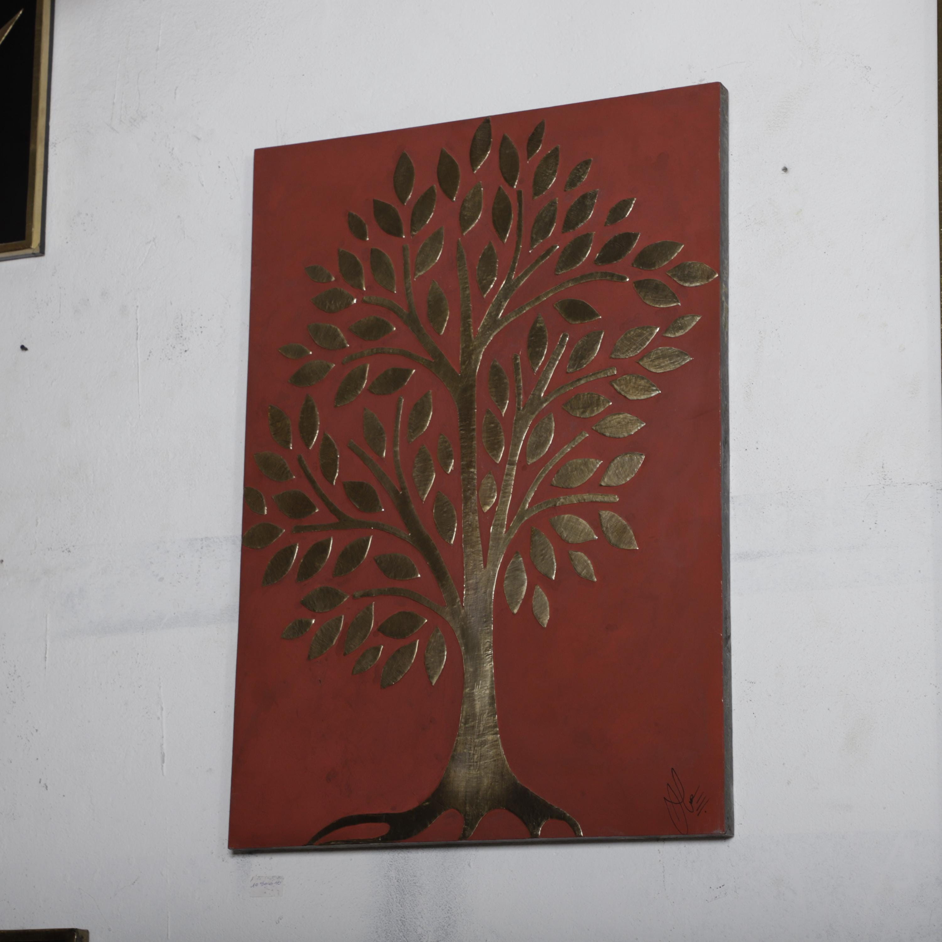 a large, red, framed artwork depicting a stylized tree with intricate leaf patterns.