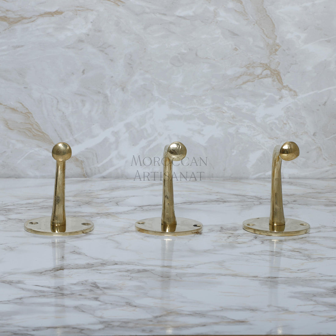 a marble counter top with three gold handles