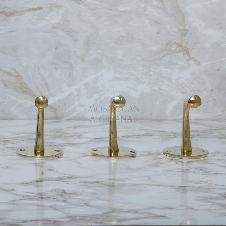a marble counter top with three gold handles