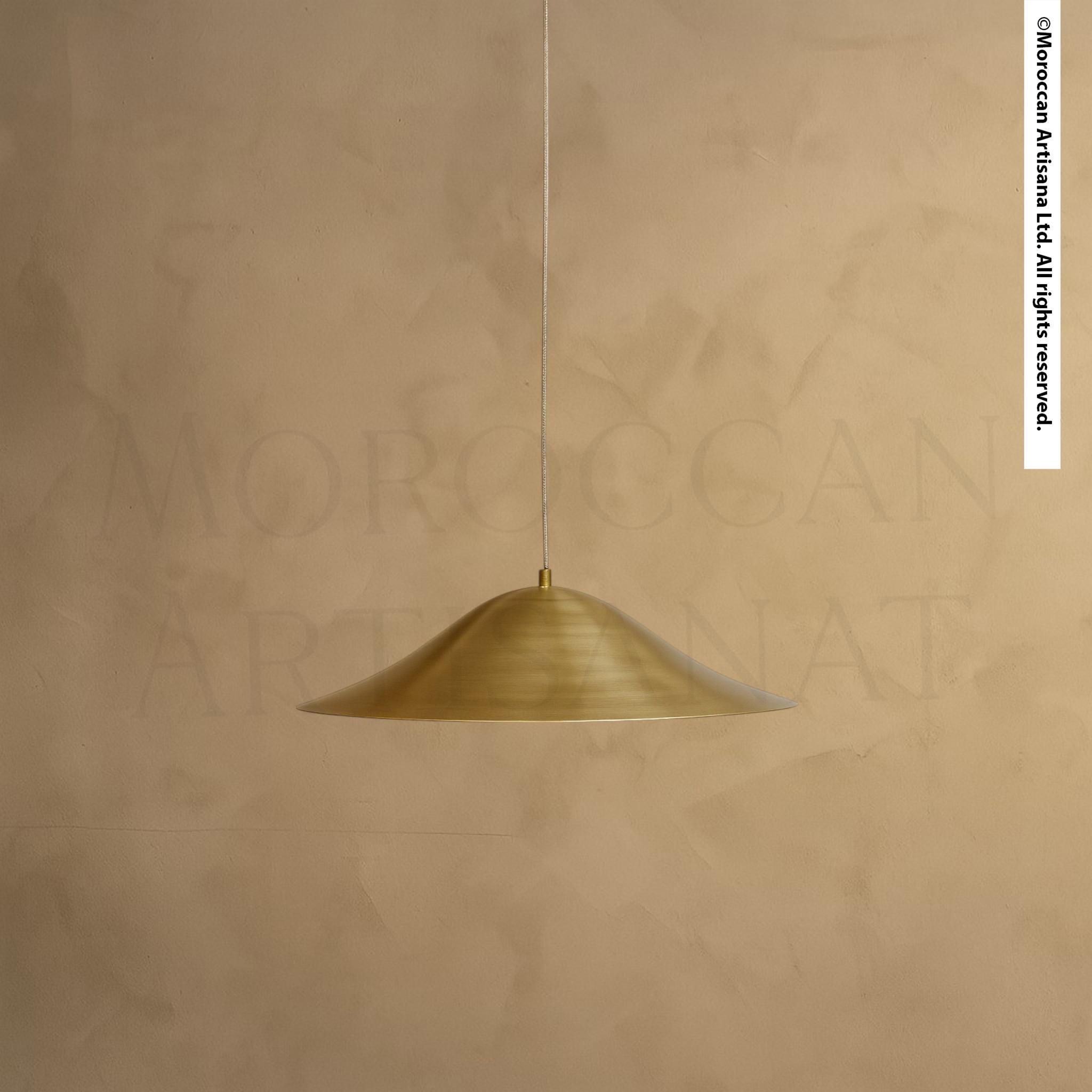 A single, gold-colored pendant light hangs from the ceiling against a beige wall.