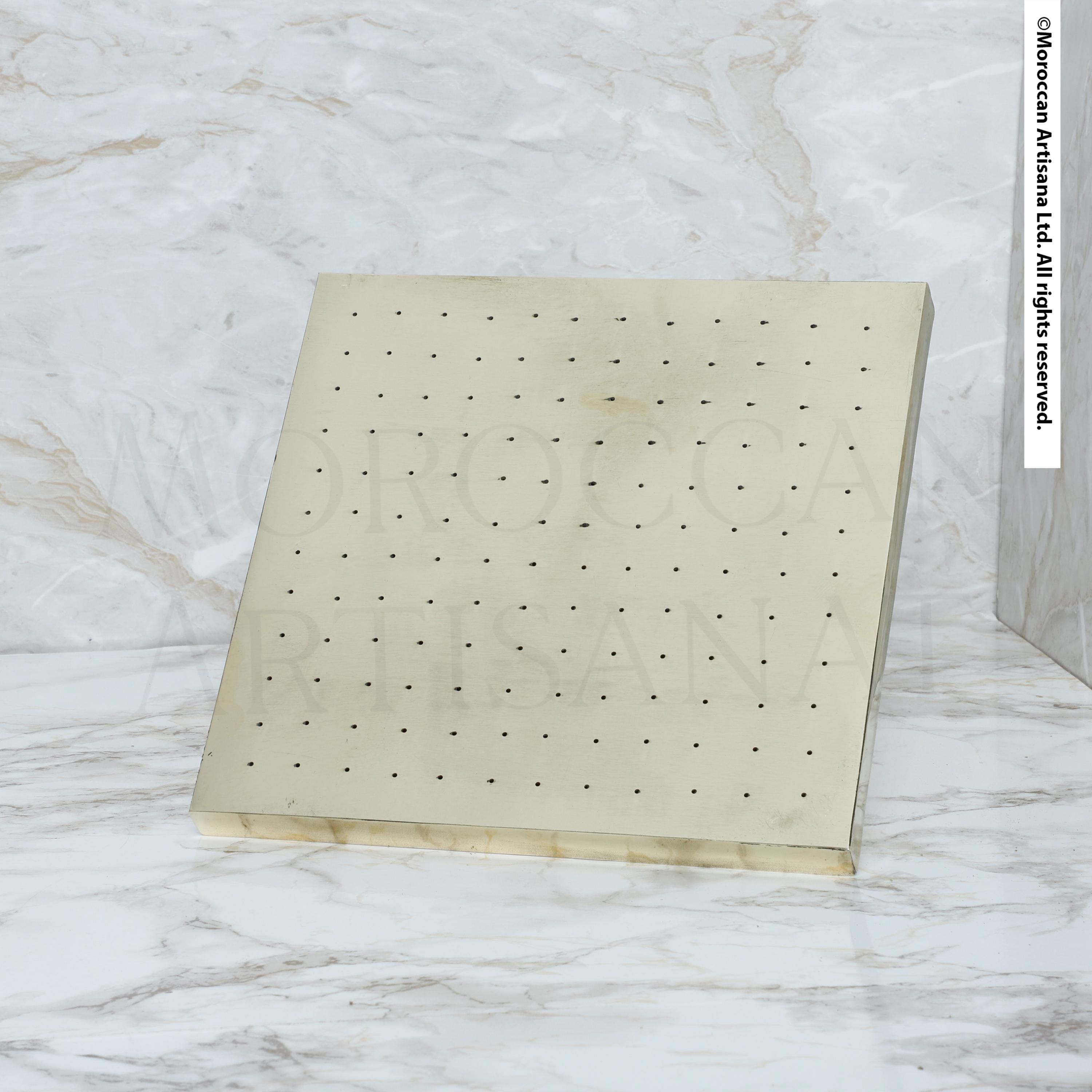 a rectangular, light-colored surface with small holes or dots evenly distributed across it.