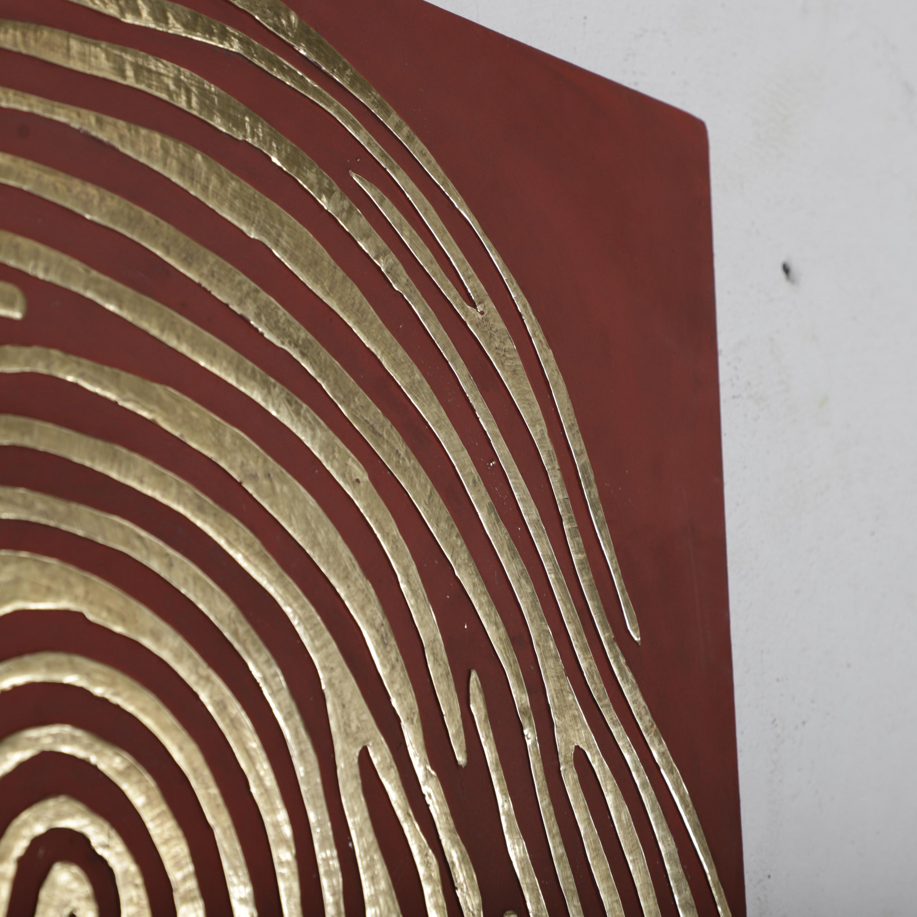 a close-up view of a red surface with a distinctive, abstract pattern resembling a fingerprint.