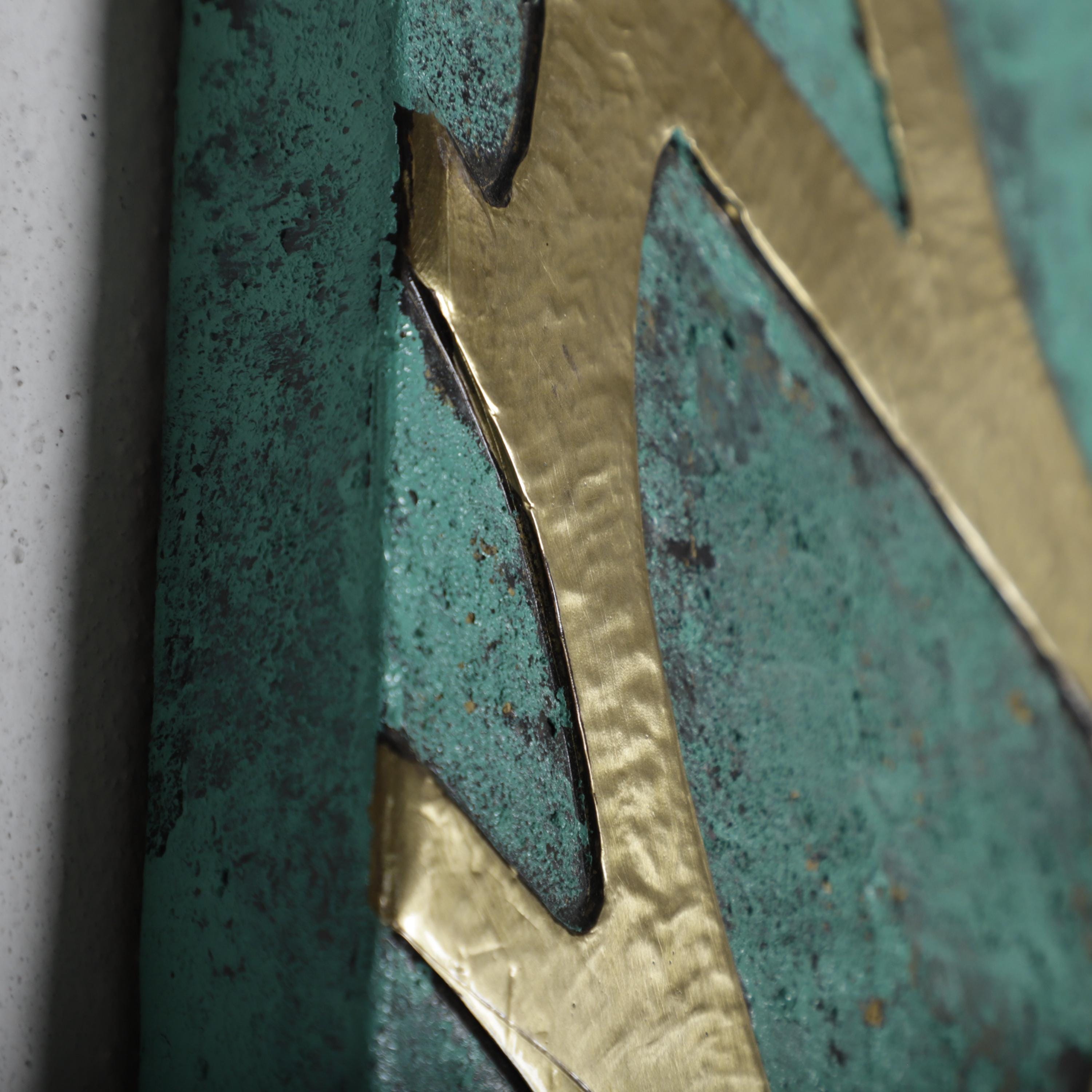 a close-up view of a textured surface with a metallic gold element, creating a visually striking contrast against the greenish-blue background.