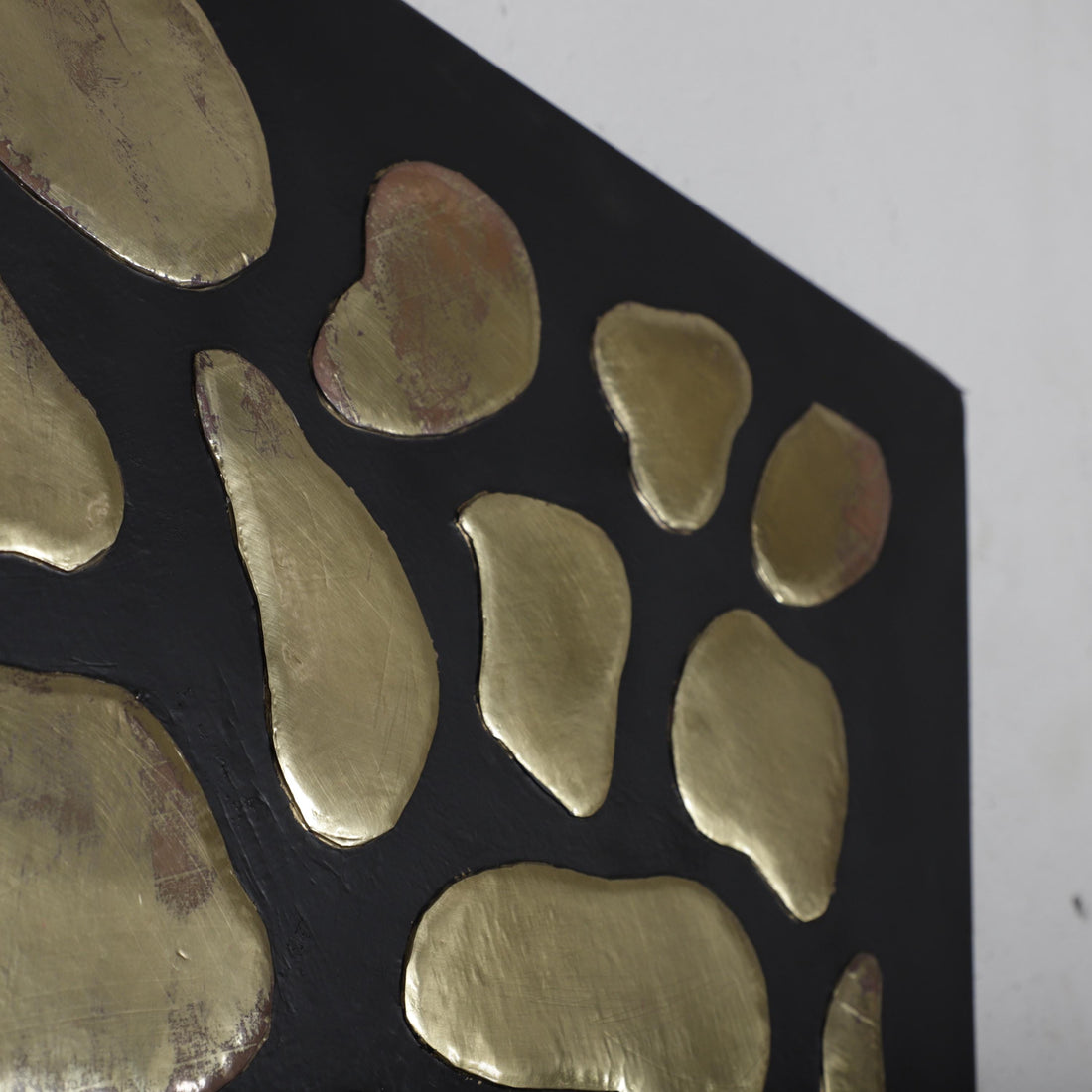 a close-up view of a black surface with a pattern of gold-colored, irregularly shaped objects arranged in a visually striking manner.