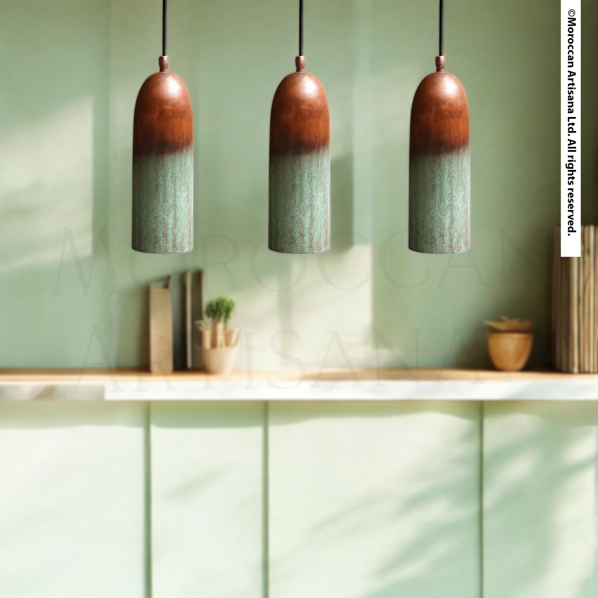 three hanging pendant lights with a rustic, wooden finish, suspended from the ceiling. The background includes a light green wall, a wooden shelf with various decorative items, and a plant.