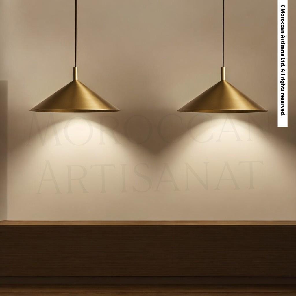 two gold pendant lights hanging from the ceiling, casting a warm glow on the wooden surface below.