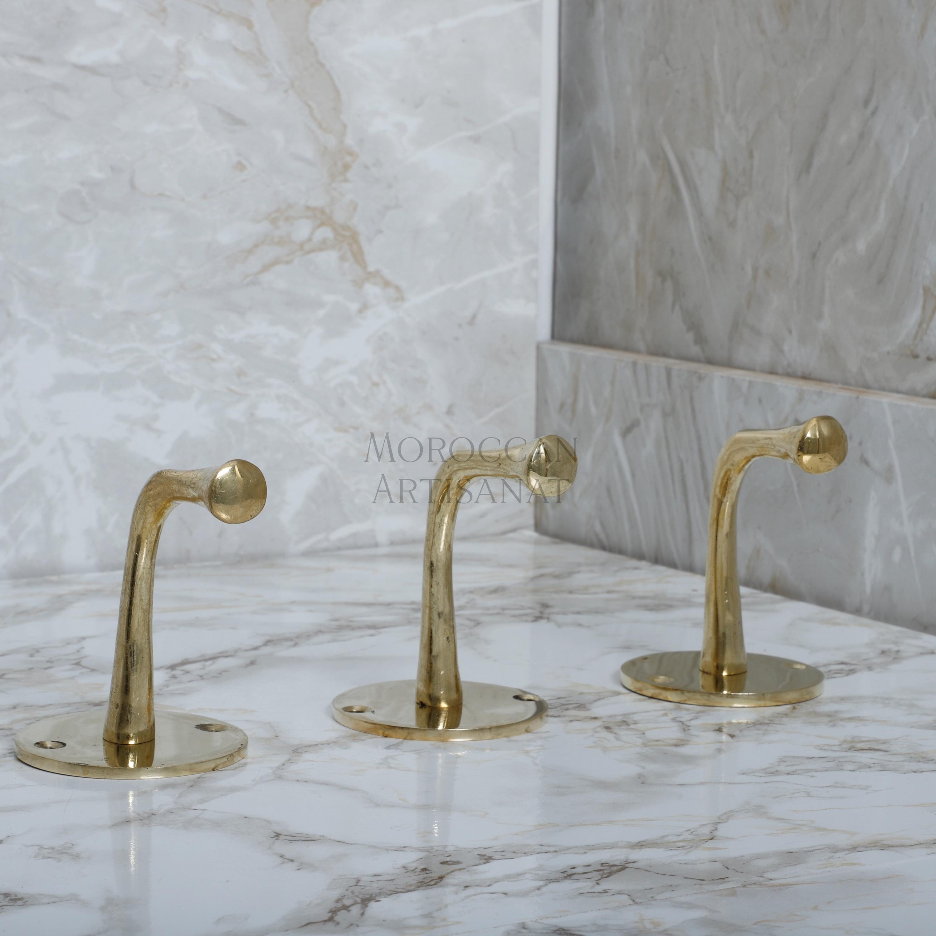 a marble counter top with two golden faucets