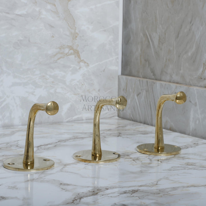 a marble counter top with two golden faucets