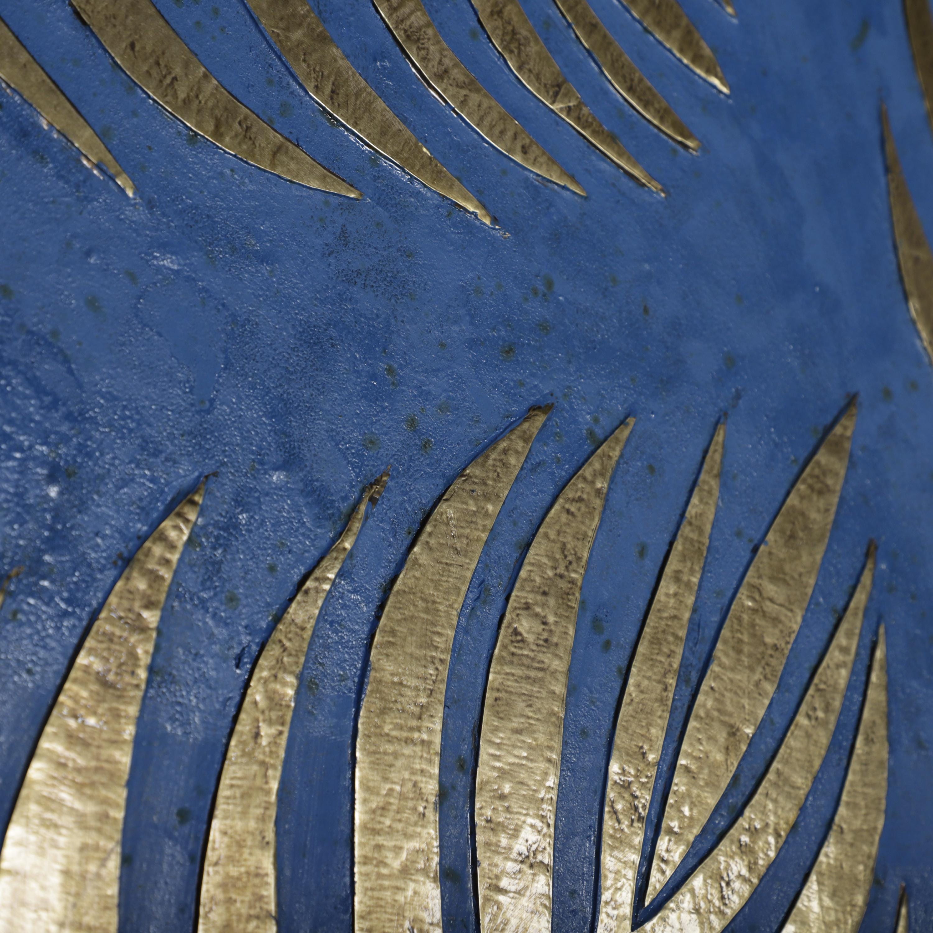a close-up view of a blue surface with a repeating pattern of gold leaf-like shapes, creating a visually striking contrast against the blue background.