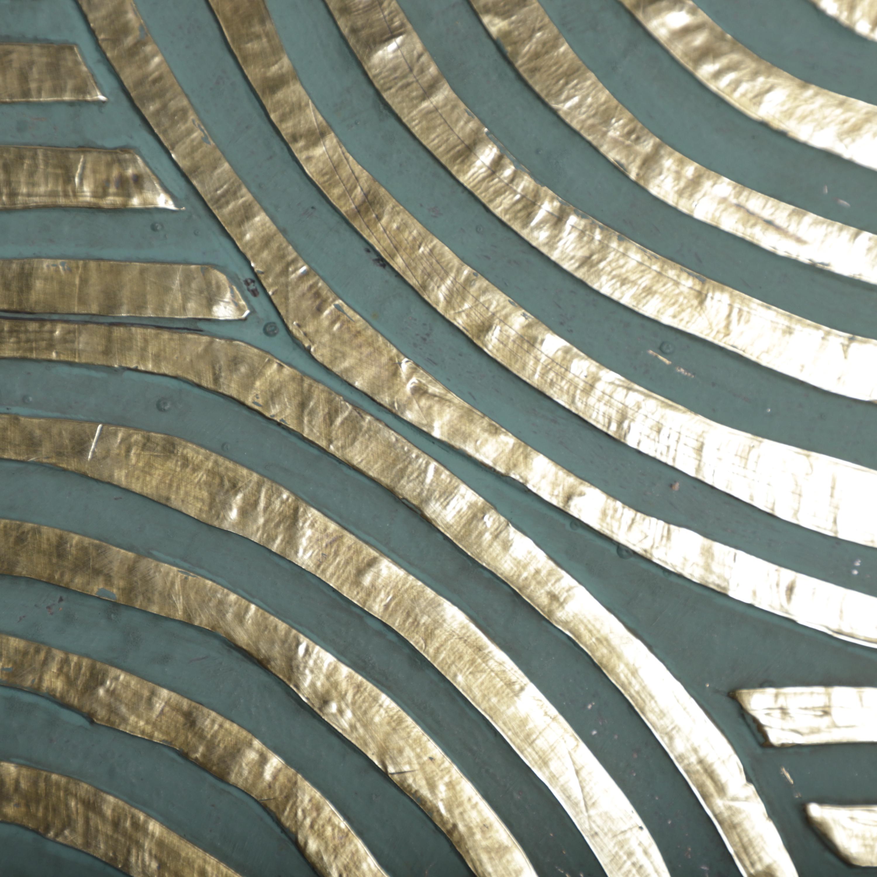 a close-up view of a metallic surface with a repeating pattern of curved lines in gold and blue colors.