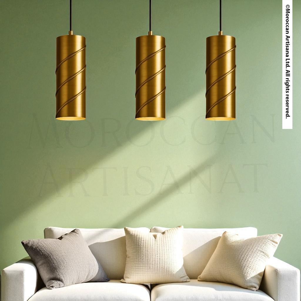 a white sofa with three gold pendant lights hanging above it, creating a stylish and modern living room setting.