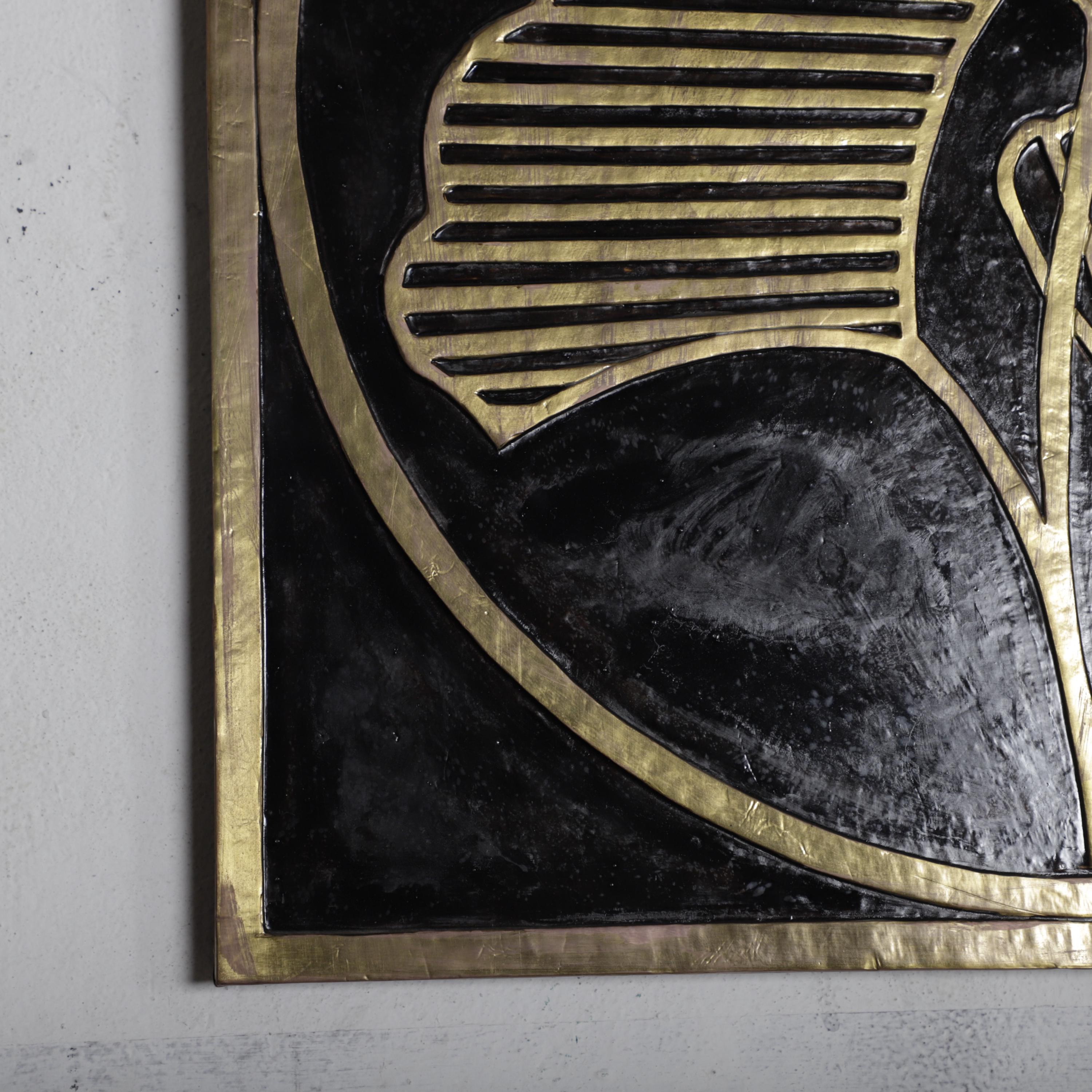 a close-up view of a black and gold decorative piece, possibly a wall hanging or artwork, with a gold border.