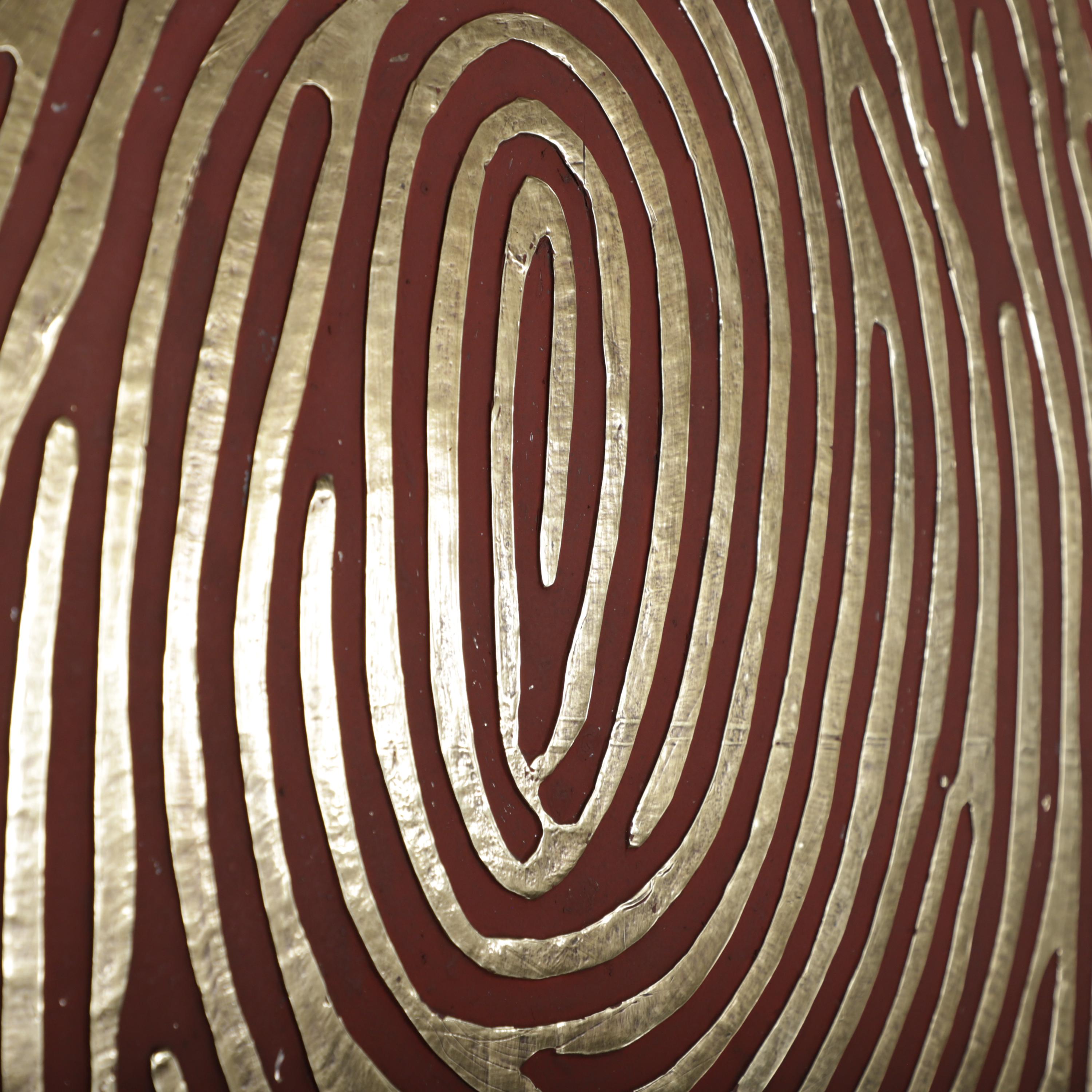 a close-up view of a pattern resembling a fingerprint, with a mix of red and gold colors.