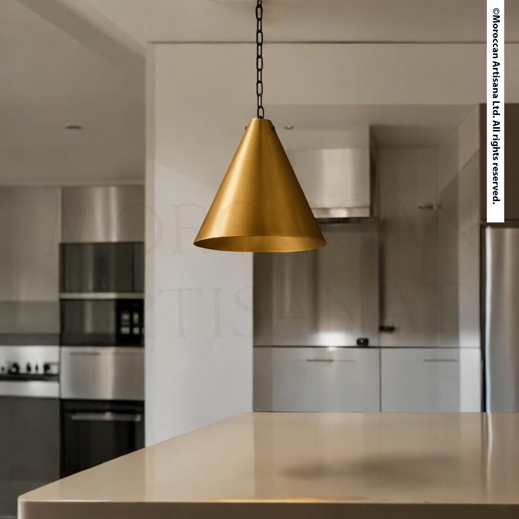 a modern kitchen with a large, gold-colored pendant light hanging from the ceiling.