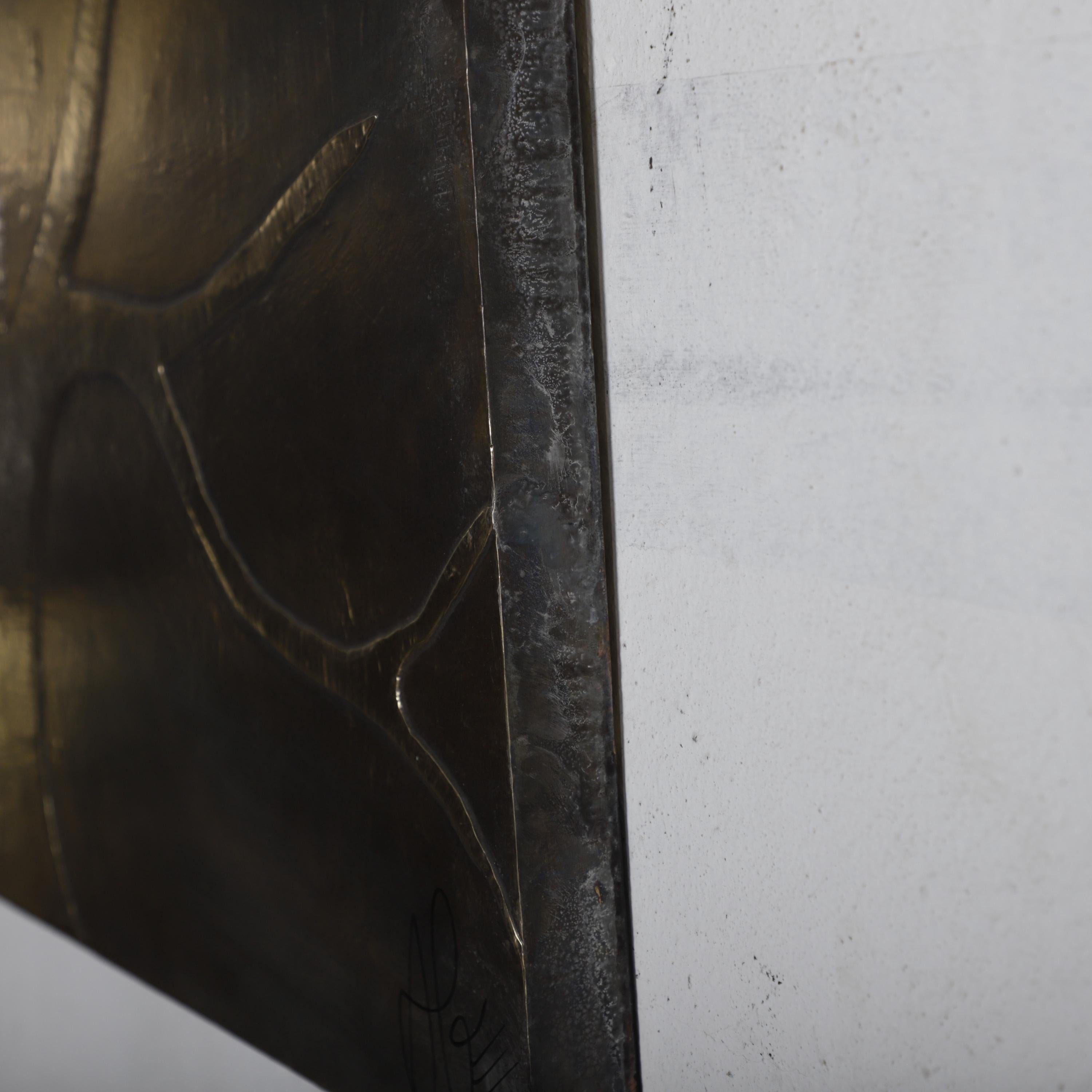 a close-up view of a dark metal surface with a textured, weathered appearance.