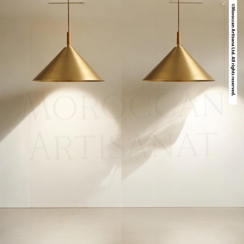 two golden pendant lights hanging from the ceiling, casting a shadow on the wall behind them.