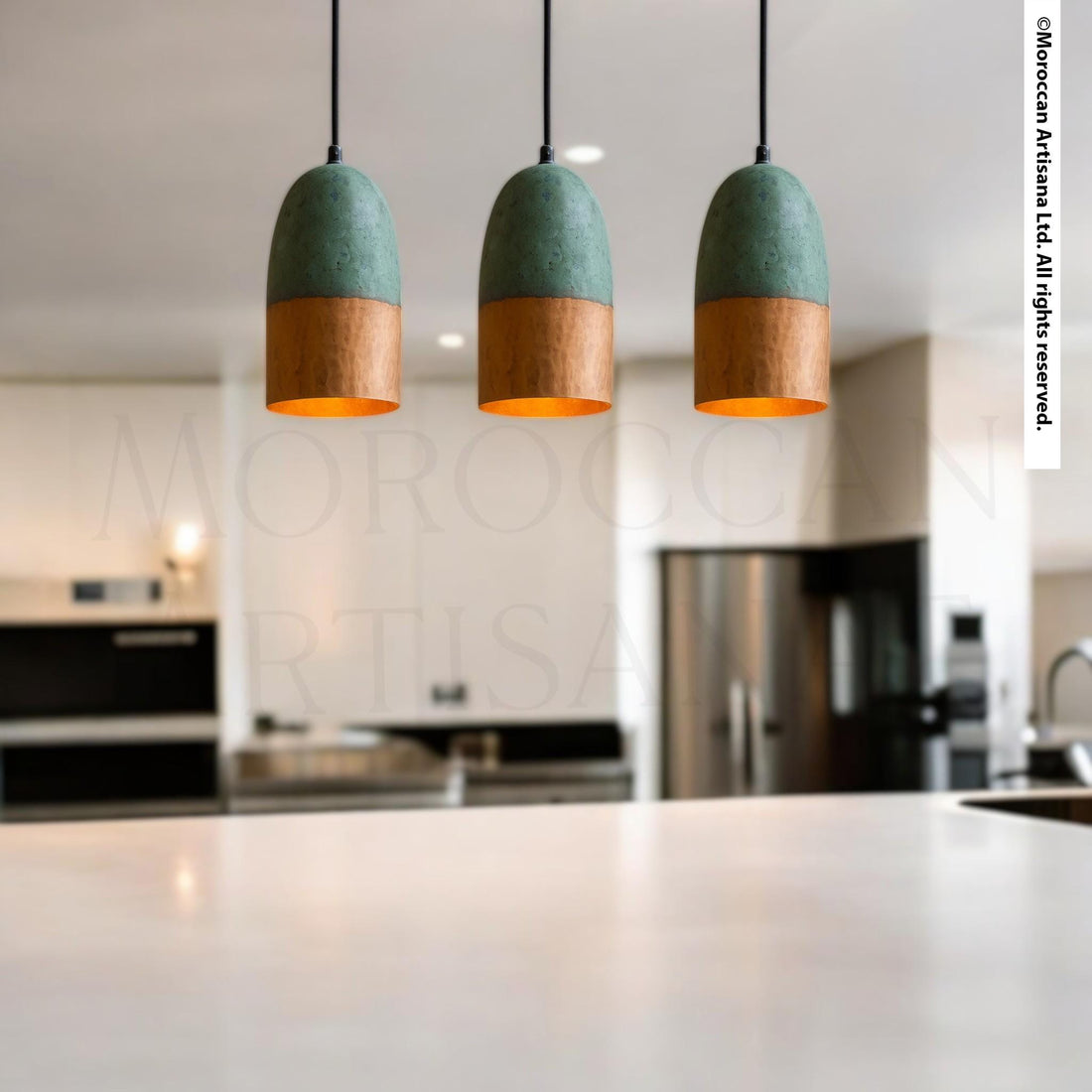 a modern kitchen with three pendant lights hanging above a white countertop.