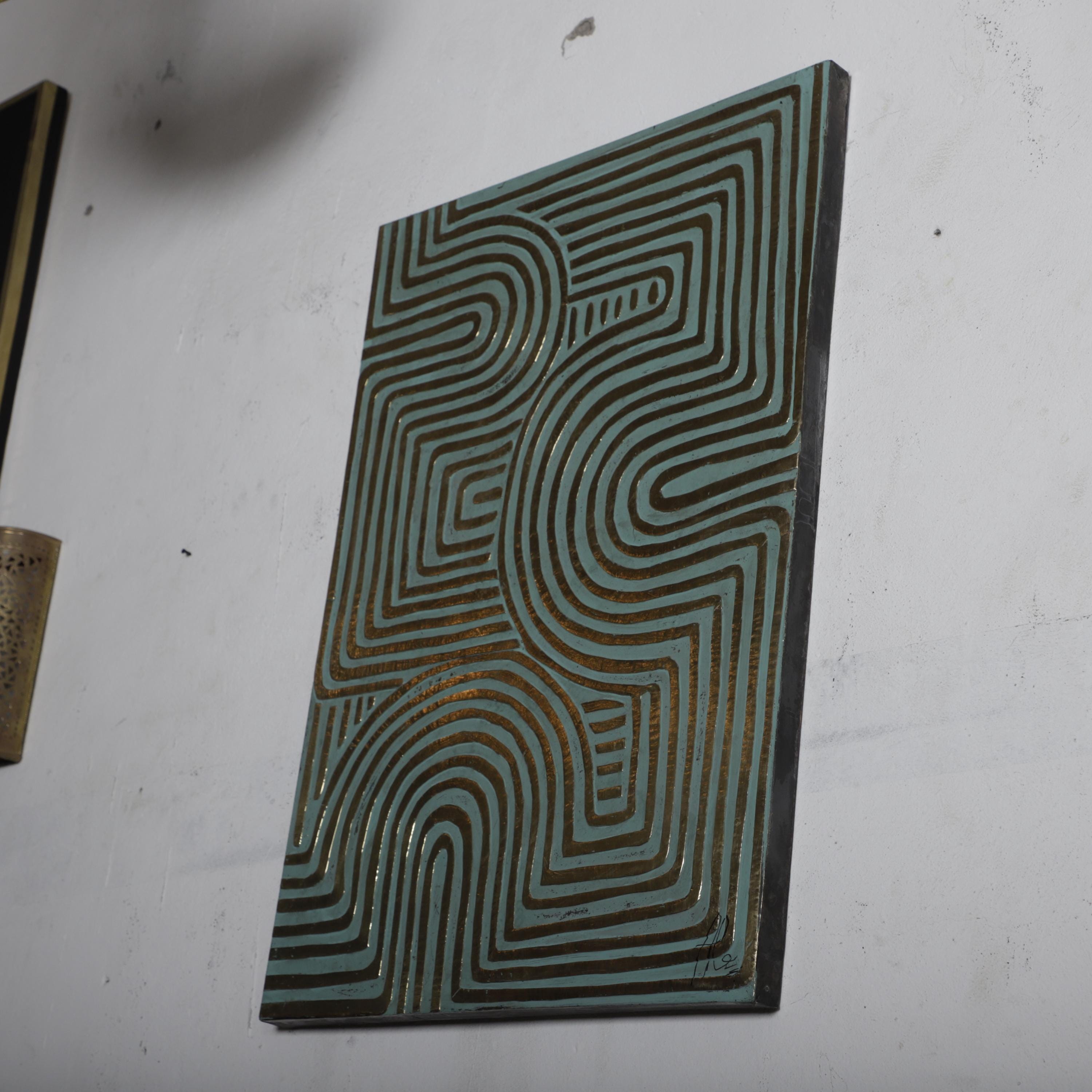 a geometric abstract artwork with a repeating pattern of curved lines and shapes on a white wall.