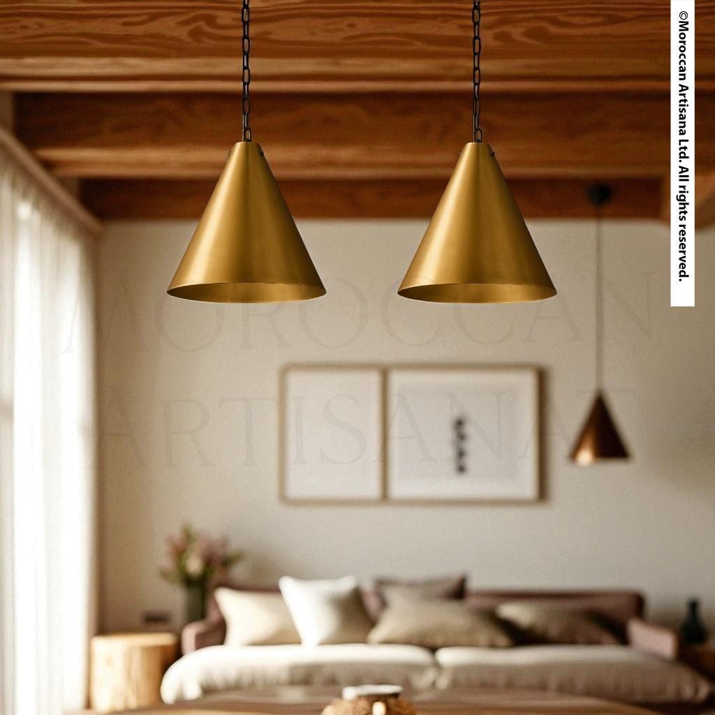 a modern living room with a brown leather couch, a wooden coffee table, and two hanging pendant lights with gold-colored shades.