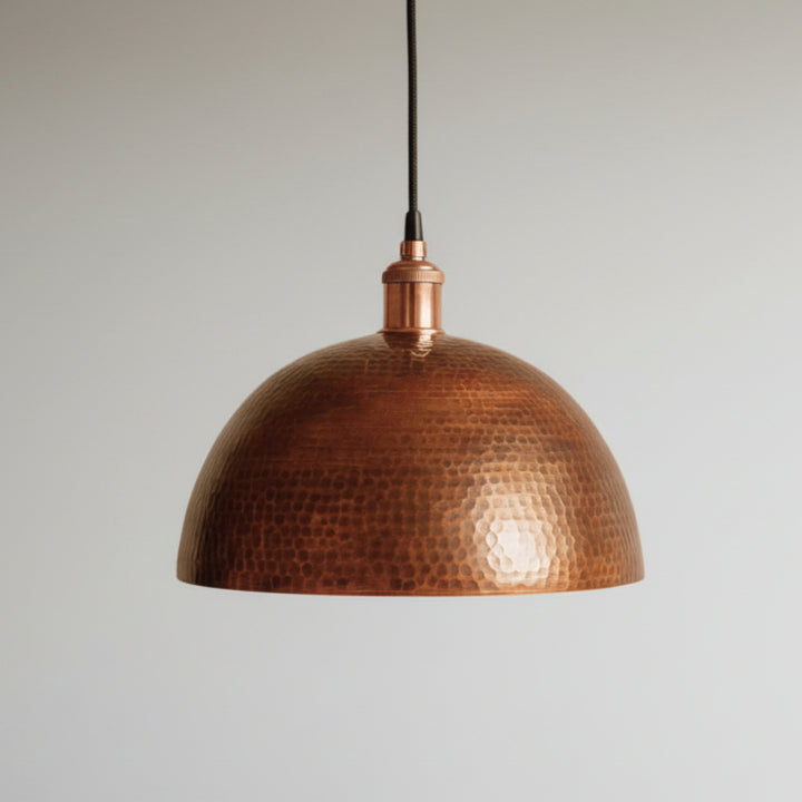 Hand-hammered copper dome pendant light with warm reflective finish, Moroccan artisan ceiling fixture for rustic or modern interiors