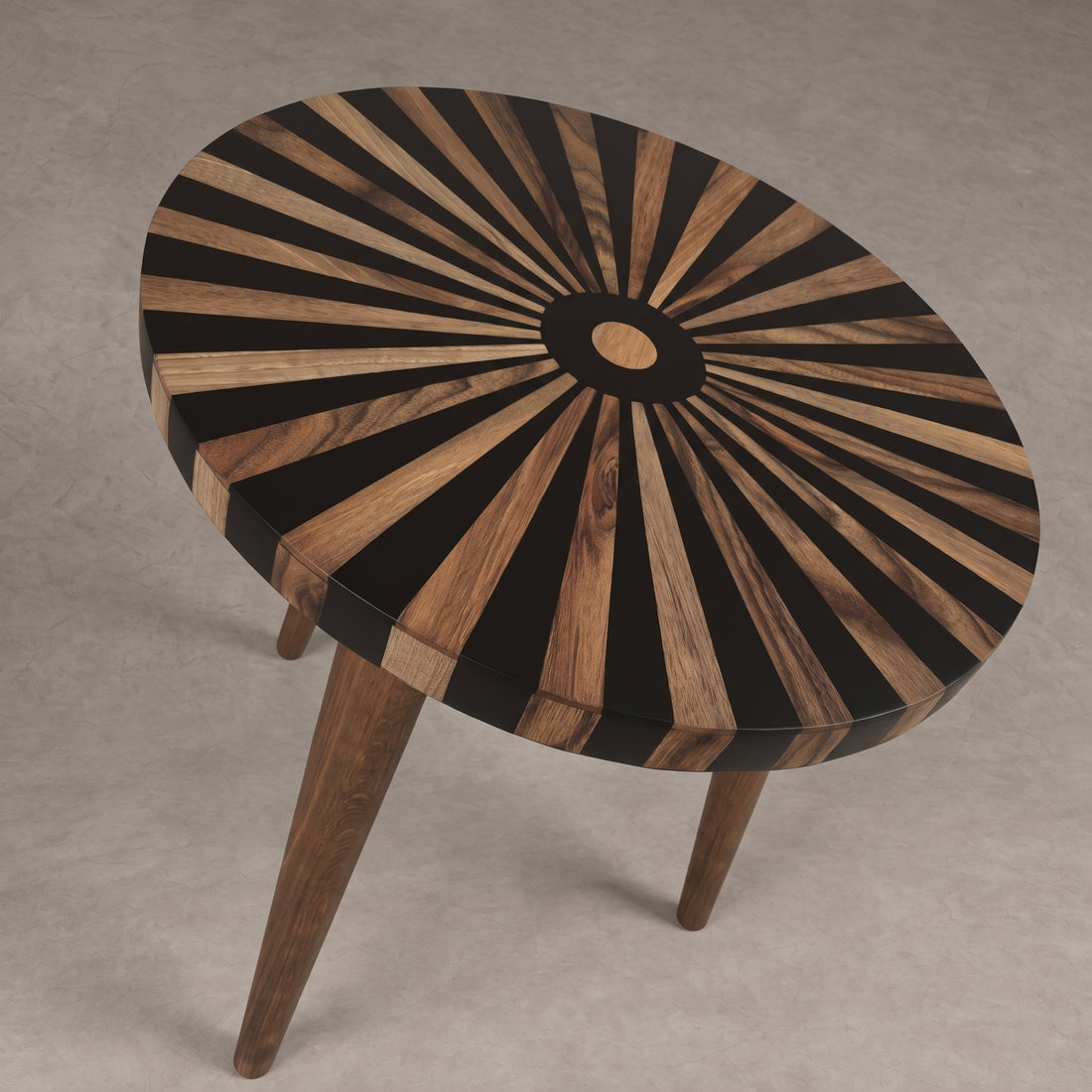 A round wooden side table with a sunburst inlay pattern on the top, featuring alternating black and warm brown wood rays radiating from a central circular detail, supported by three tapered wooden legs on a neutral gray background.