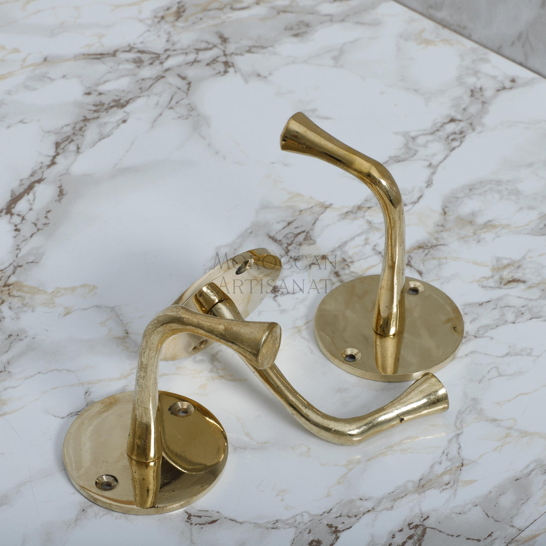 a pair of brass handles on a marble counter top
