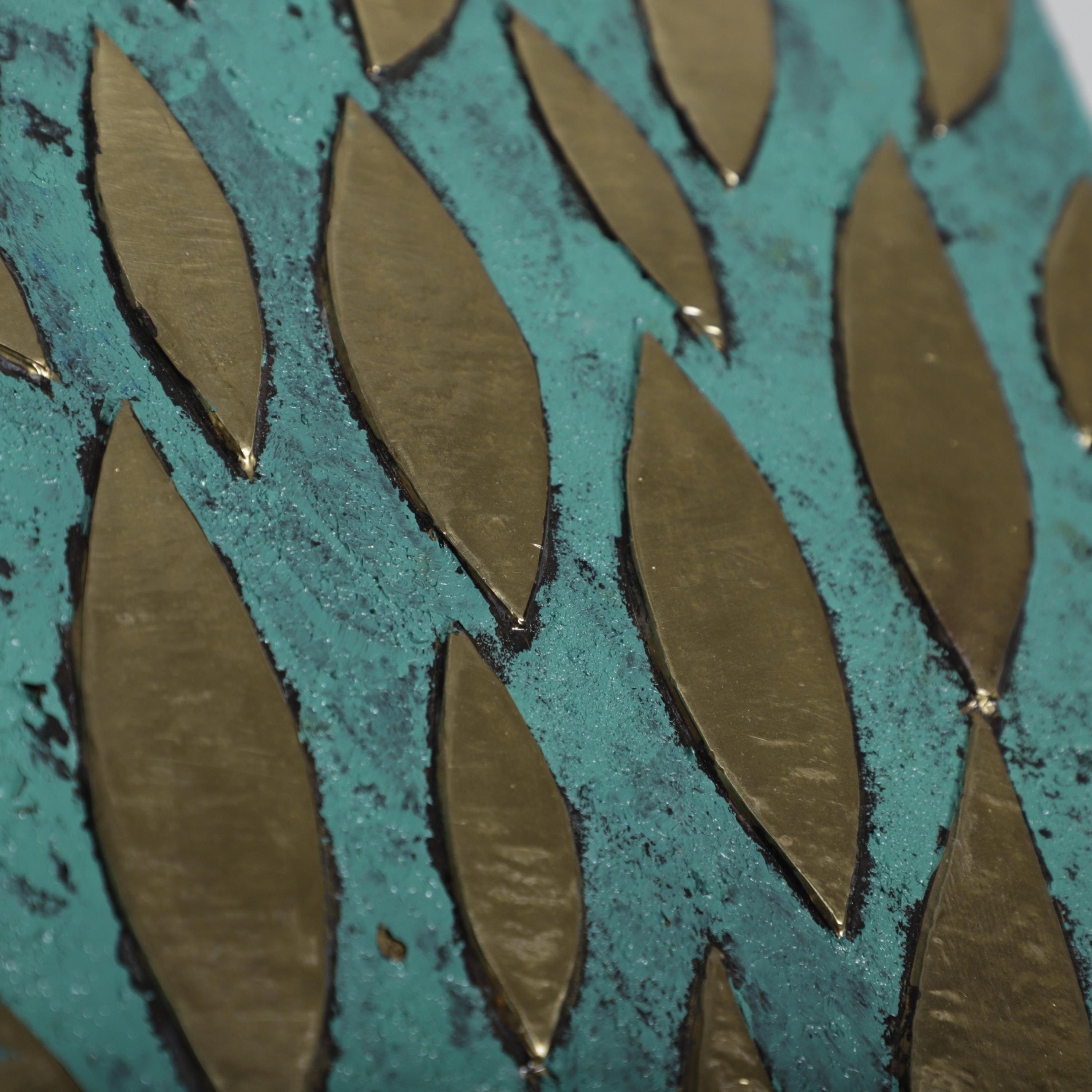 a close-up view of a textured surface with a pattern of overlapping, metallic-looking shapes in shades of green and brown.