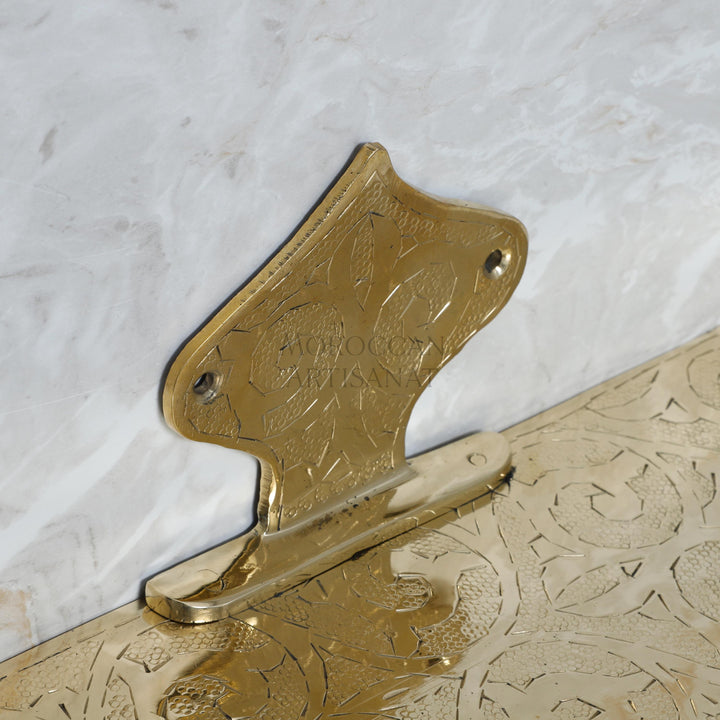 a gold metal object on a white marble surface