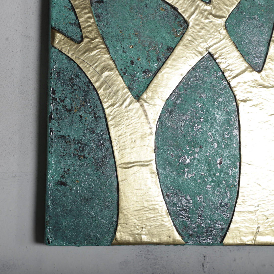 a close-up view of a piece of art, showcasing a striking contrast between the green and gold colors. The artwork is composed of various shapes and textures, creating a visually captivating piece.