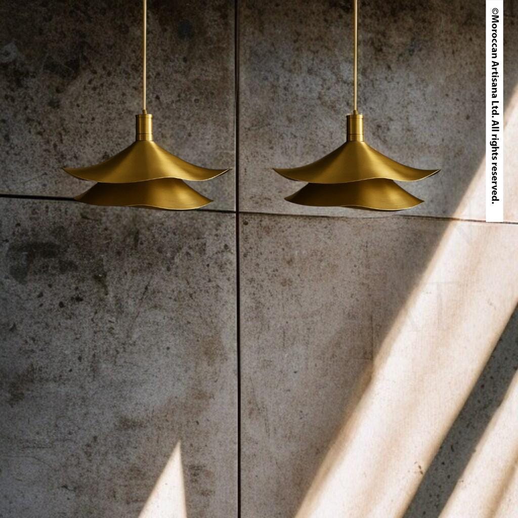 two gold-colored pendant lights hanging from the ceiling, casting a shadow on the wall below.