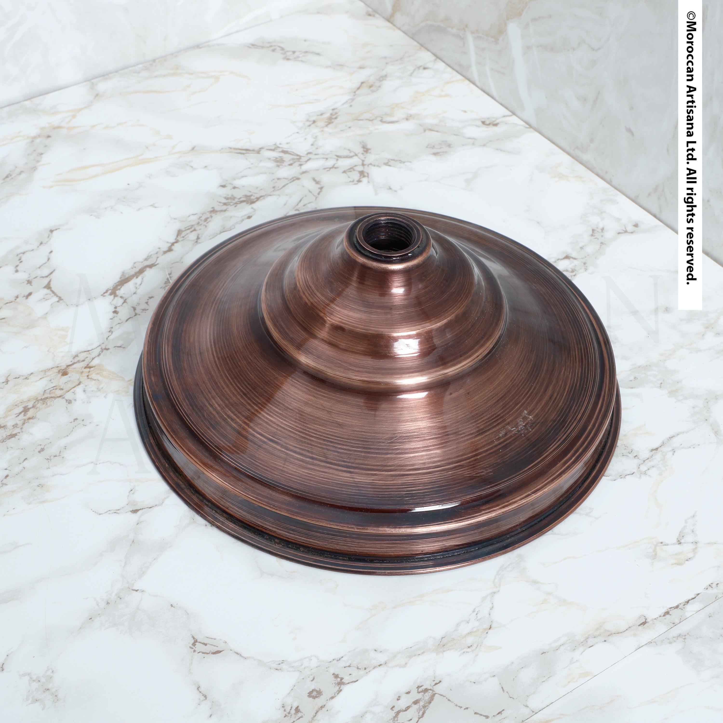 a round, metallic object with a textured surface, resting on a marble countertop.