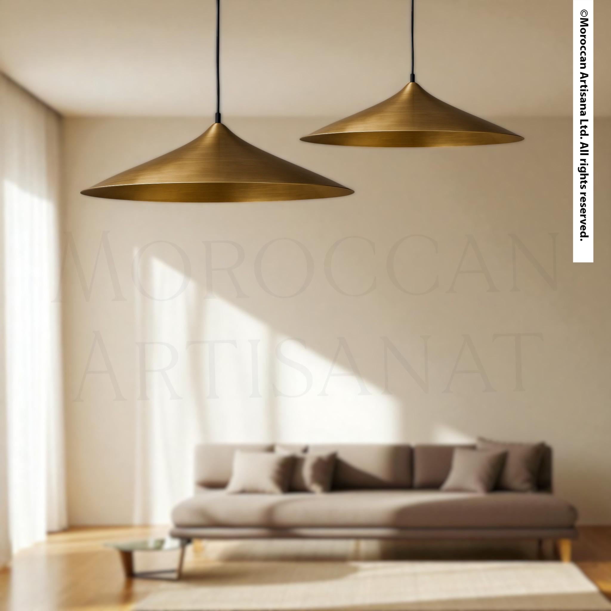 a modern living room with a gray sofa and two pendant lights hanging above it.