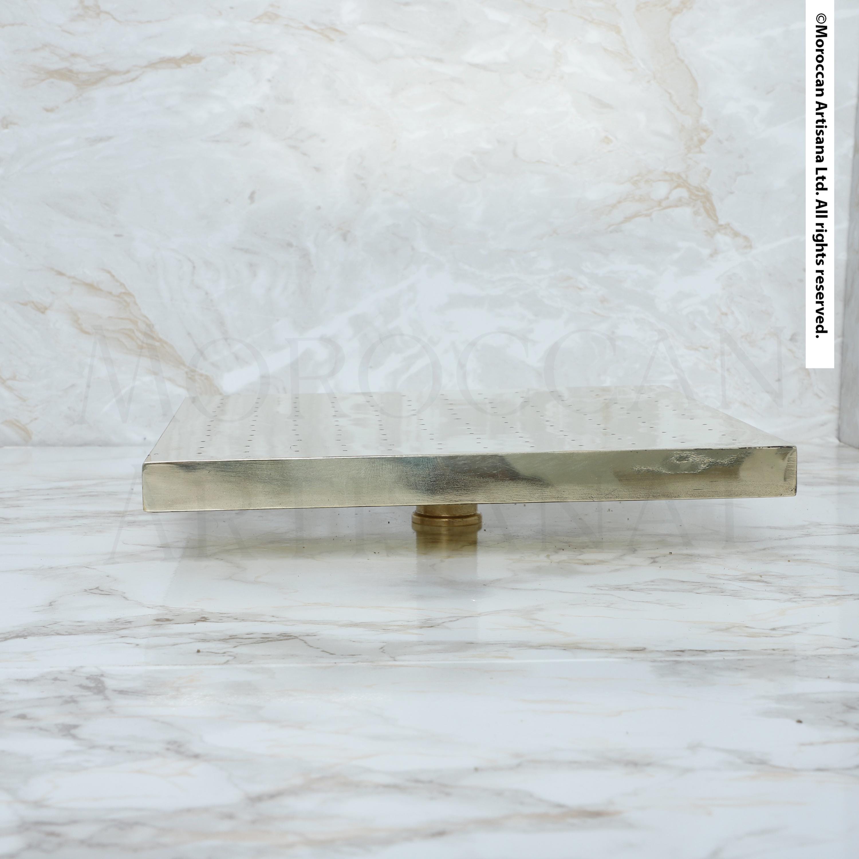 A metallic, rectangular object sits on a marble surface, with a textured, marble-like background.
