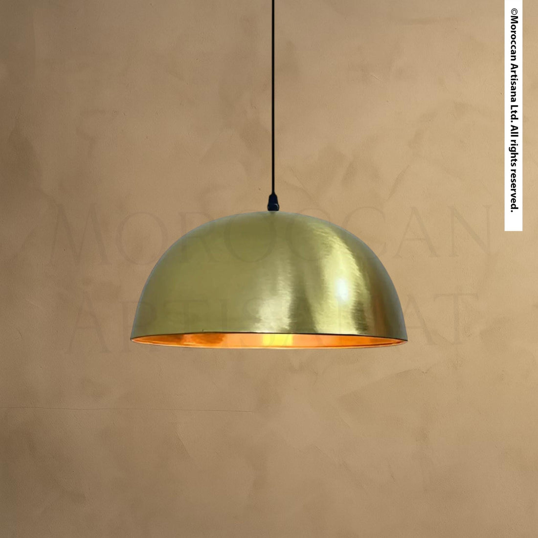 A gold-colored pendant light hangs from the ceiling against a beige wall.