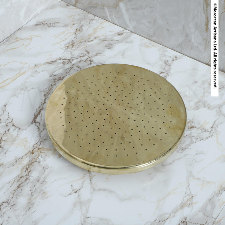 a round, metallic object with a textured surface, placed on a marble countertop.