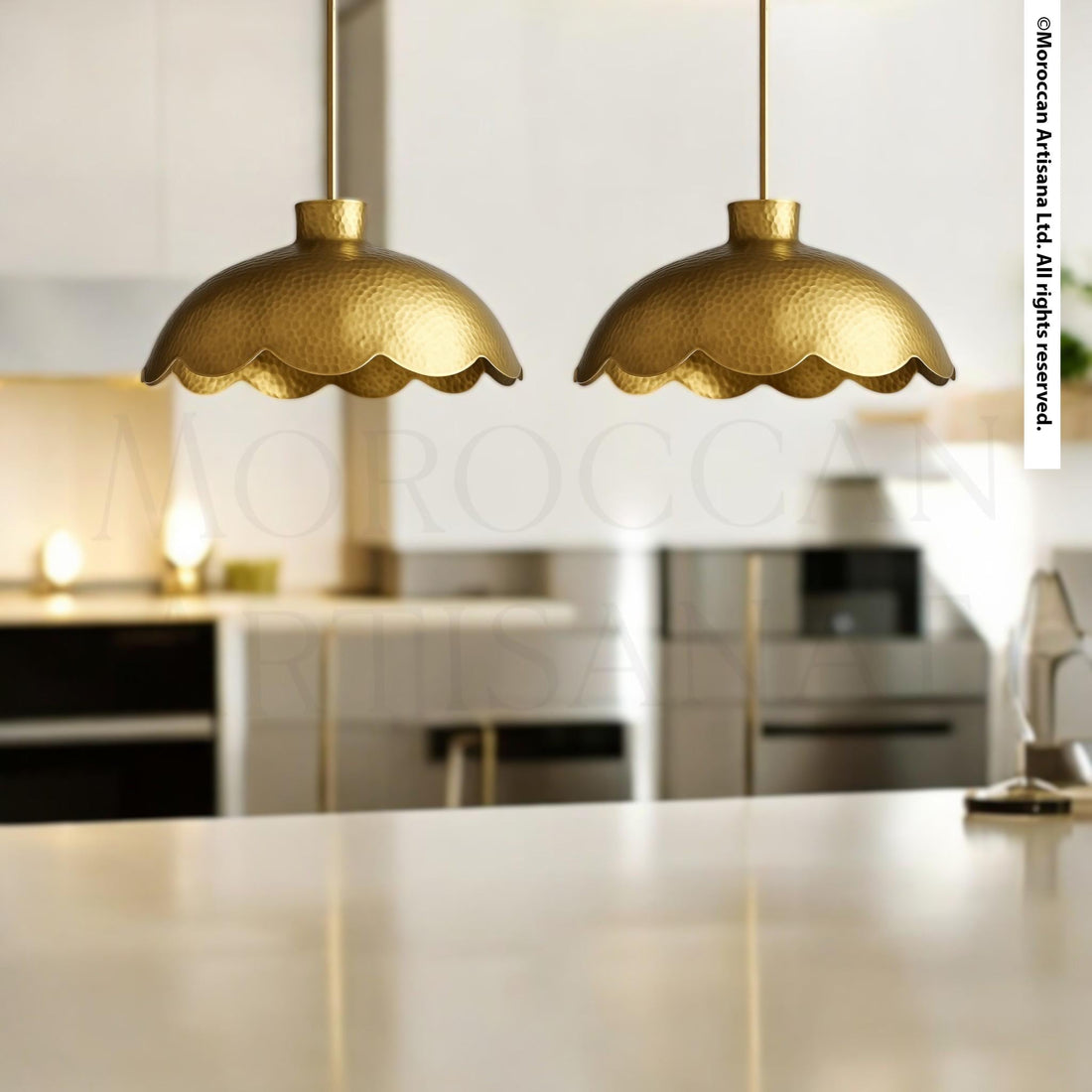 two gold-colored scalloped pendant lights hanging from the ceiling in a kitchen setting.