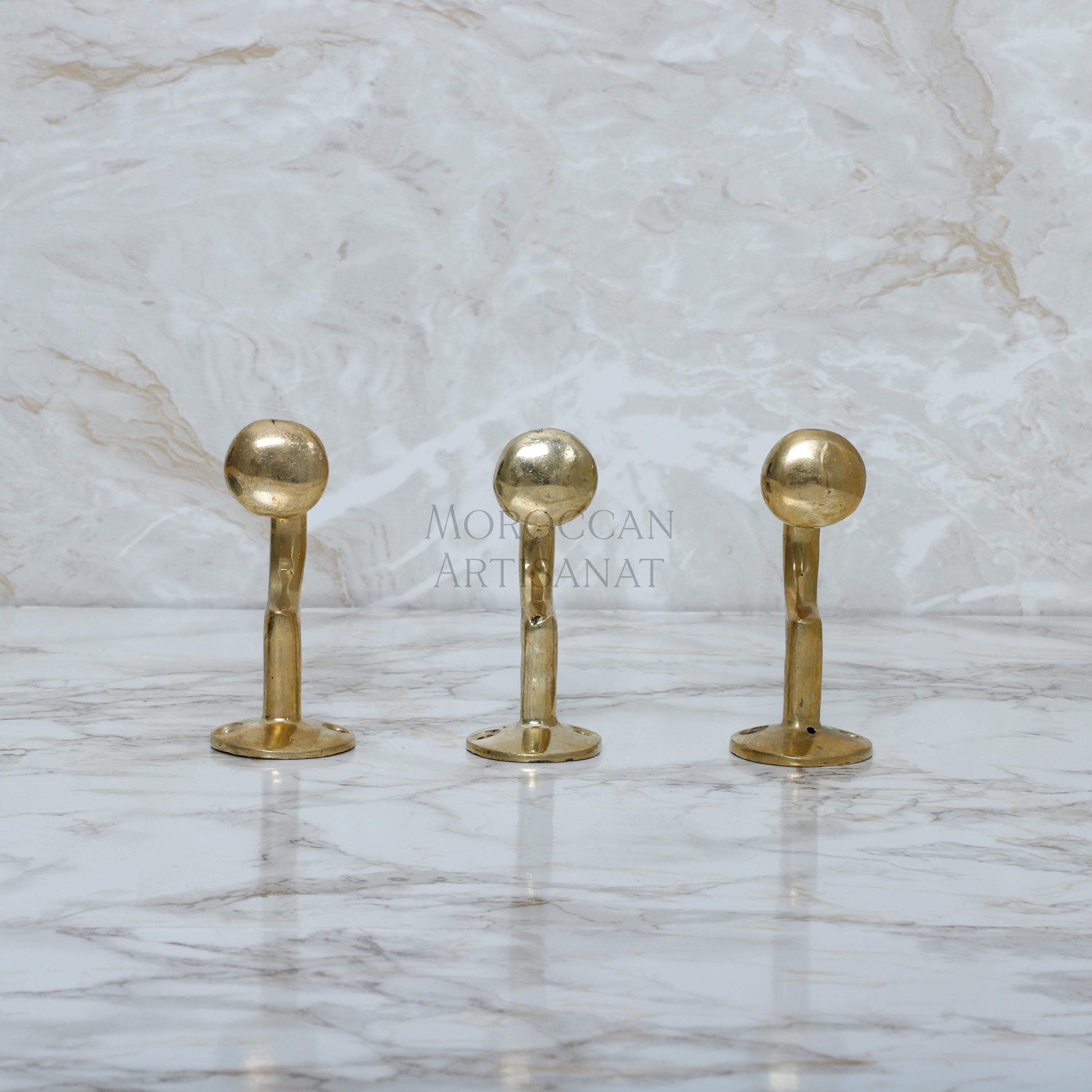 a marble counter top with three golden handles