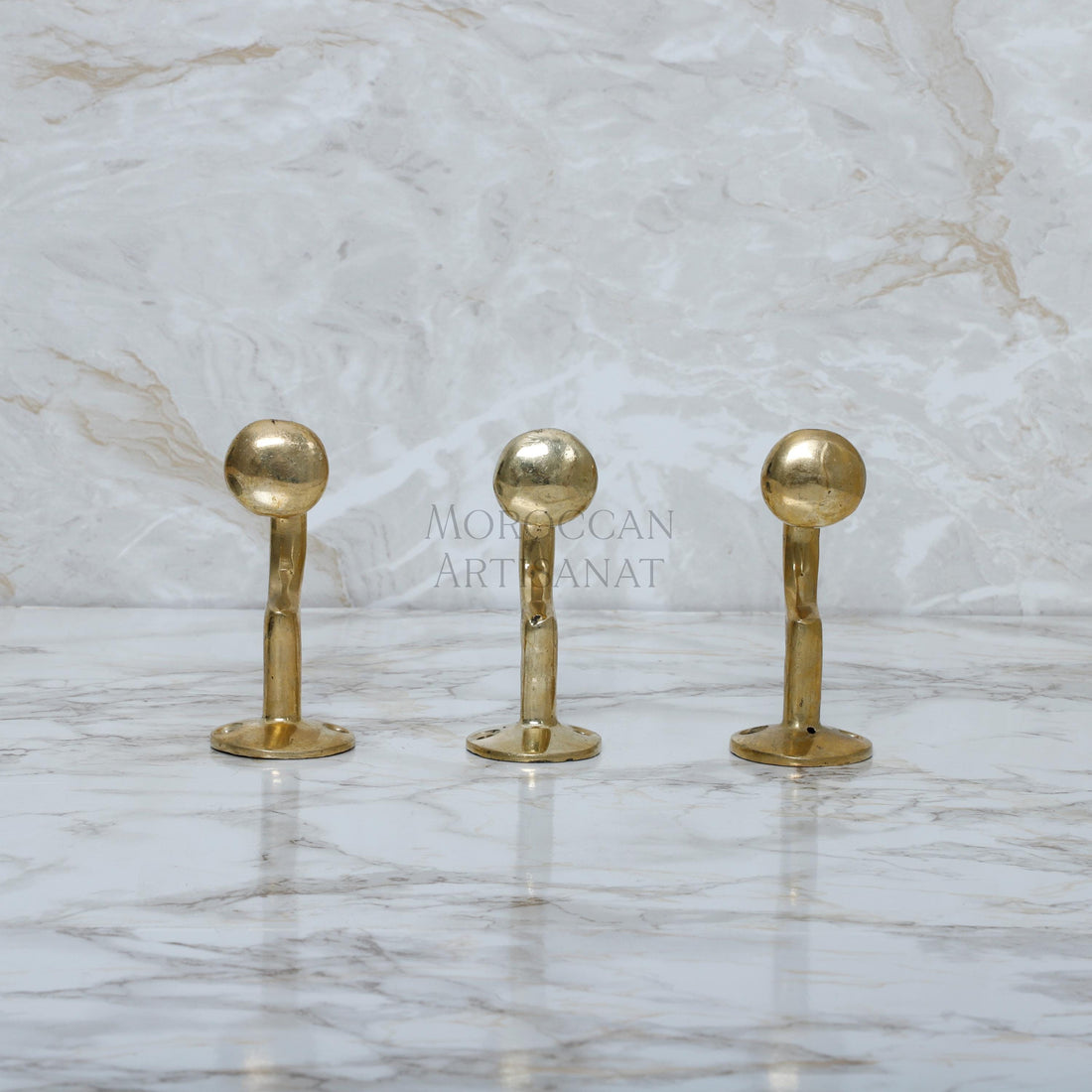 a marble counter top with three golden handles