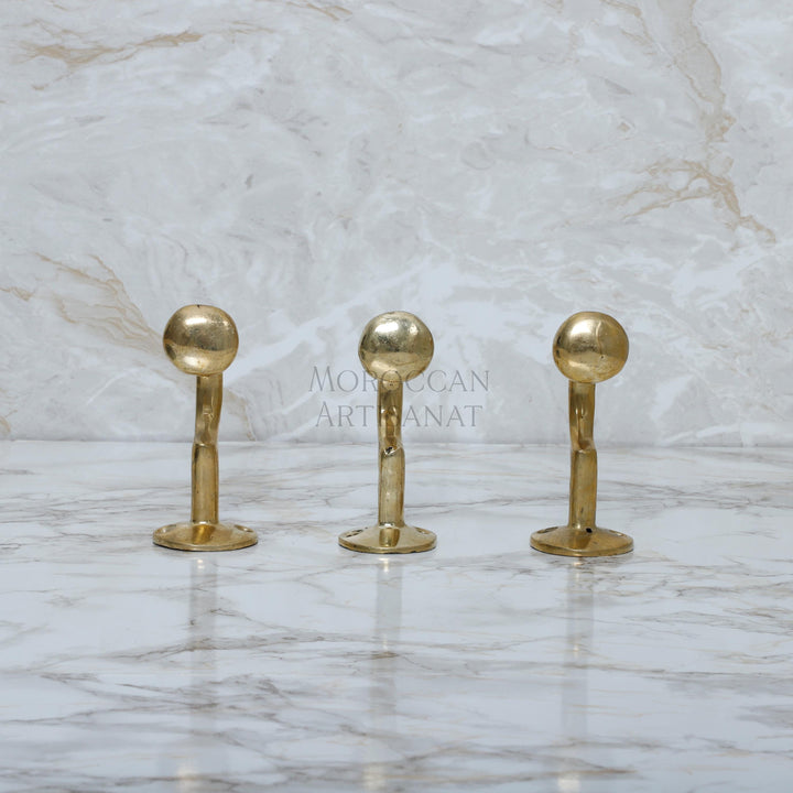 a marble counter top with three golden handles