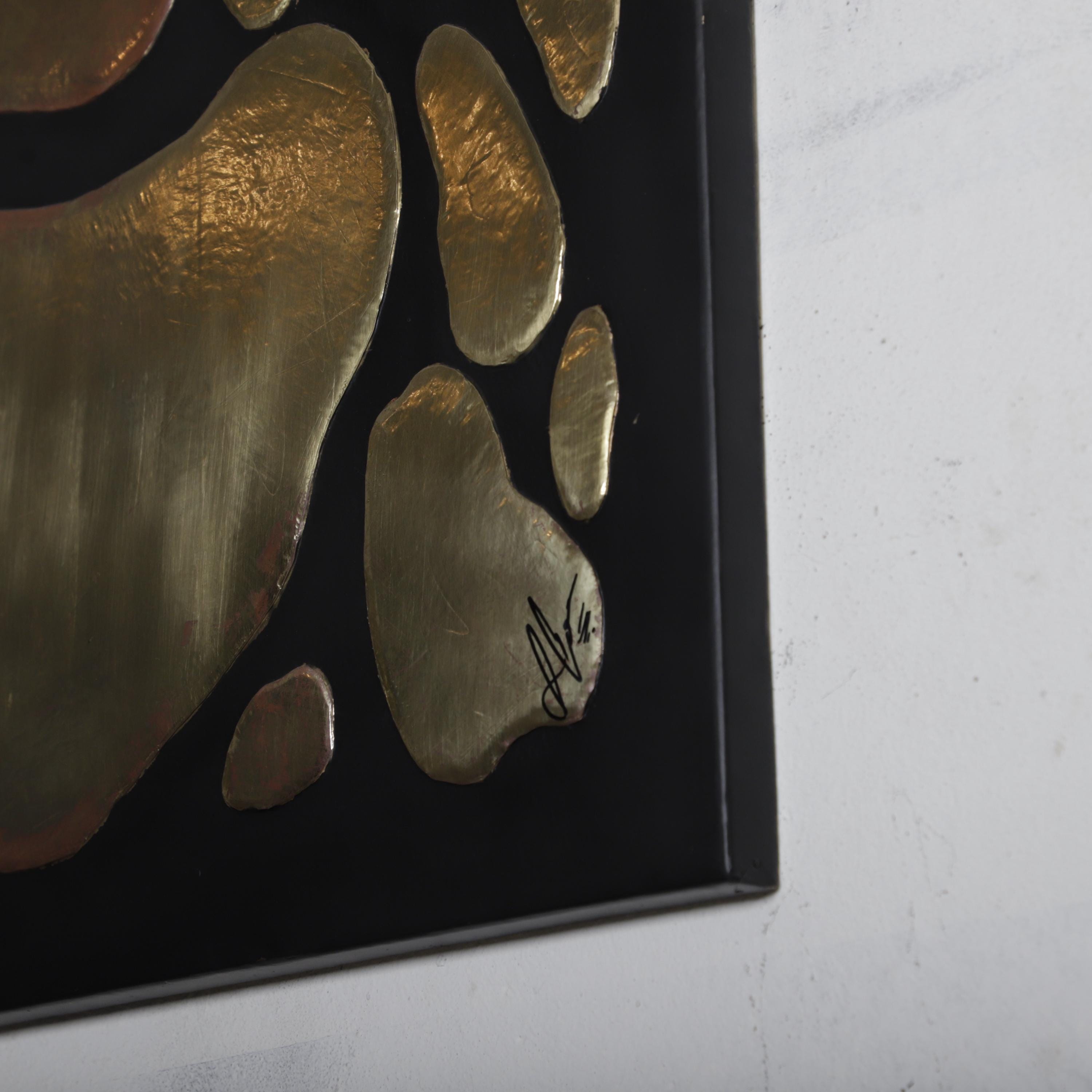 a close-up view of a black surface with a gold-colored, abstract design composed of various shapes and sizes.