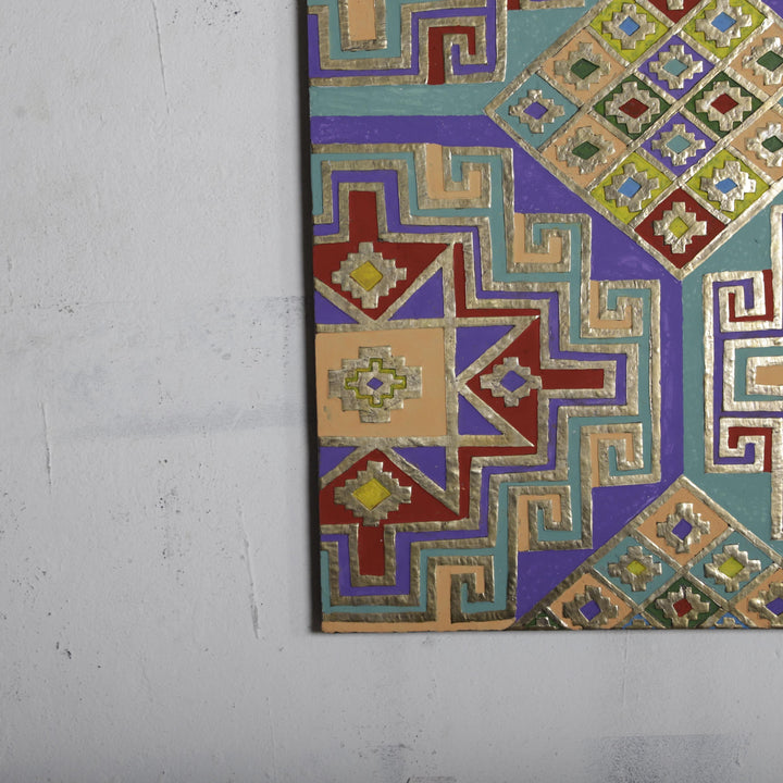 a vibrant, colorful, and intricate geometric pattern with a variety of shapes and designs, including diamonds, triangles, and squares, all set against a plain white wall.